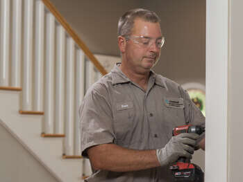Technician performing handyman services in a residential home