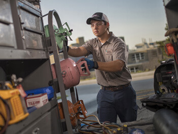 Technician getting service equipment out of a work vehicle